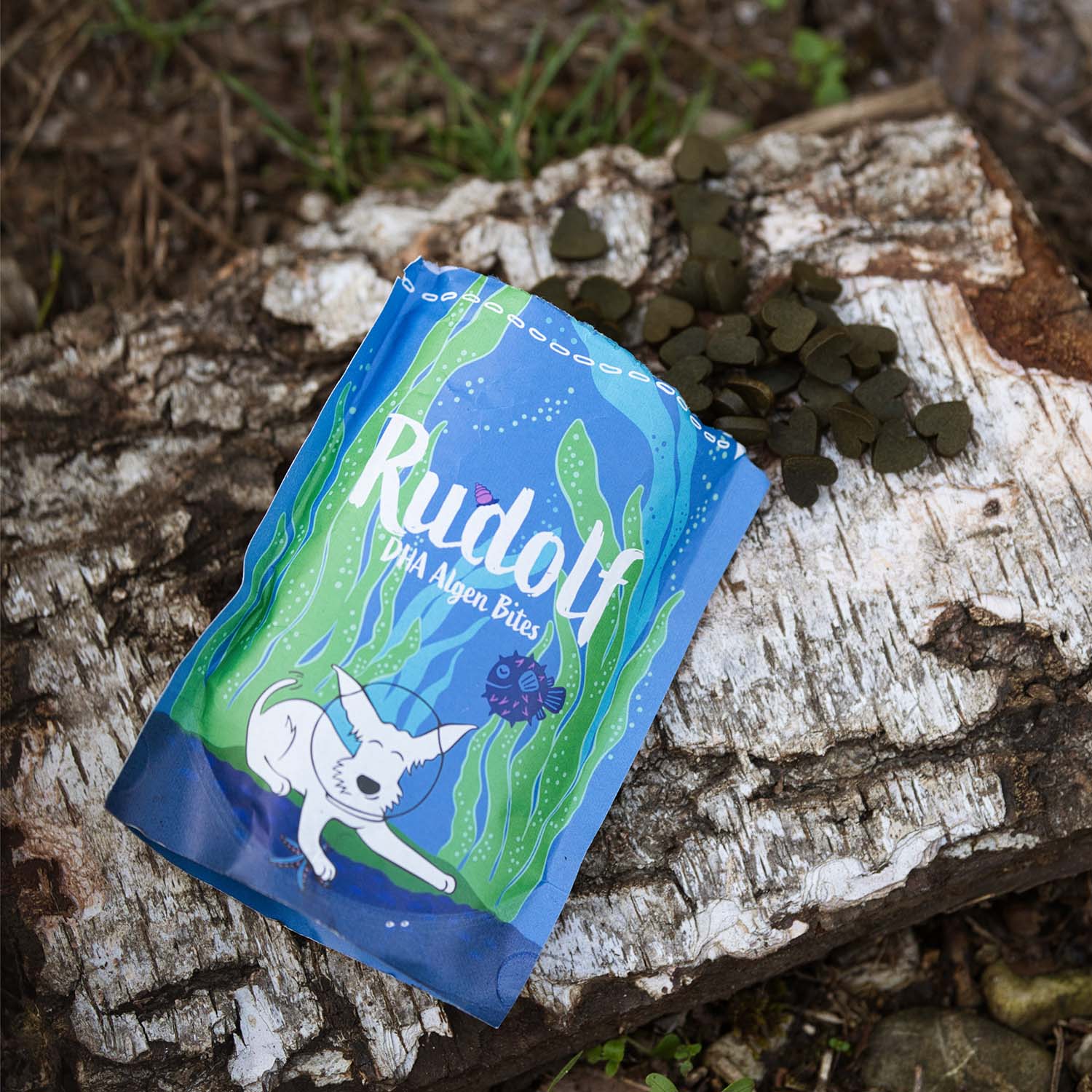 Heart-shaped Rudolf Algae Bites by Vegan4Dogs on natural birch bark – vegan dog snack for essential DHA supply.